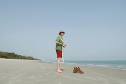 Me, white European, red short, green torn Langnesse, T-shirt, hat, standing on south beach of Bubaque, Arquipelago dos Bijagos. Islands. Guinea Bissau.
