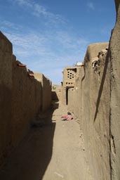 Narrow alley in Sanga, two kids play in dust. Dogon Country.