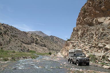 Land Rover and goats and a stream
