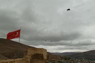Bayburt, snow on mountains, view from castle, Turkish flag and crows.