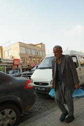 Old man, baggy trousers, plastic bag, Mardin, Turkey.