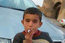 Child on parking in Ani, smokes cigarette.