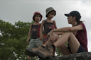 Xunantunich, C. and the boys. In back over the jungle dark rain clouds are towering high.