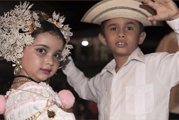 Little boy and hat, little carnival girl with head gear and dress and gold and all, pose. Carnival Panama, Las Tablas.