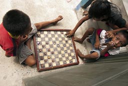 Children playing board game San Ignacio/Tupiles, Guna Yala. Panama.