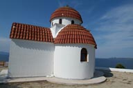 Small, orthodox greek white chapel, blue sea and sky.