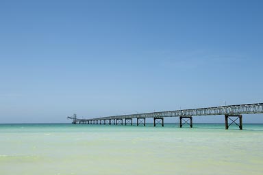 Colorada Beach, blue clear water, crisp sky. Logistics, conveyor facilities for near-by salinas. Salt loading. Yucatan, Mexico.