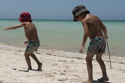 What is here to do?  On Playa Colorada, boys search on white sandy beach what to do.
