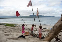 Raising fishing net boyes and the flags on poles, boys and girls on dunes of Chipehua, Mexico.