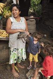 Lady selling bananas has a raccoon.