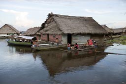 In Iquitos, flaoting home, family, clothes washing, men in boat. Peruvian Amazonas River. 