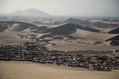 Between dunes a dusty village, near Ica, Peru.
