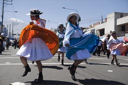 Traditional dresses from all regions, red and blue dance down Independence Avenida, Arequipa Day Peru.
