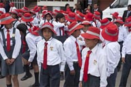 On a Sunday, parading in Huancayo, kids and red hats.