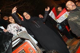 Muslim Egyptian woman celebrating football team's victory in streets of Cairo.