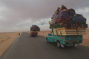 Western Egyptian desert road, pick up trucks fully/over loaded.