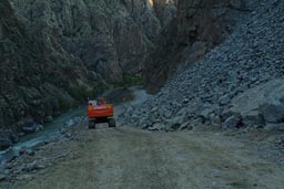 Hitachi bulldozer rolls down the river Coruh valley, destruction, Turkey.