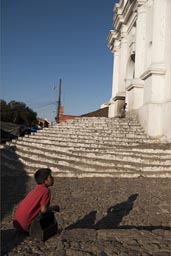 Saint Thomas church, Chichicastenango late light on steps, shoe cleaner boy in red. Guatemala.