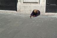 Begging old woman on pavement, Rome.