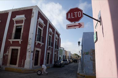 Stop/Alto Sign and Street Corner, old town Campeche, man rolling a tire. 