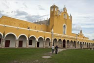 Priest walking accross courtyard/atrium, Izamal, Yucatan.