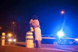 Hugging at night. Police blue light in back, Mexico, Acapulco.