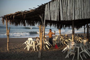 Raking a beach cafe, early morning. Puerto Arista.