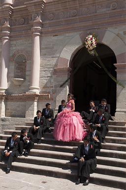 Quinceaneras, possible grooms surround 15 year old Mexican girl.