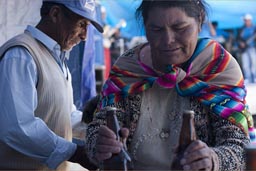 Old indigenous woman brings two bottles of beer, Coipasa, Bolivia.