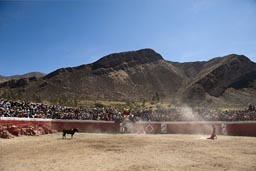 Mountains, bull fighting arena in Huambo, packed with local people. Peru. 